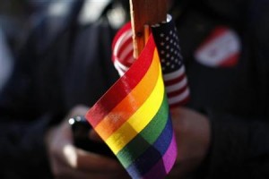 A marriage equality supporter holds gay pride and American flags